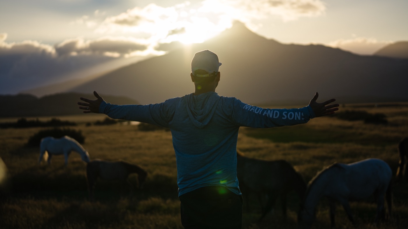 Arms open at sunset among wild horses, Patagonia